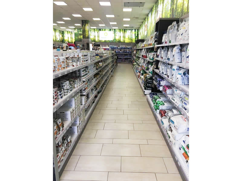 Arredi per negozi di PET FOOD con scaffalature in metallo e schienali legno in colore cemento e Visual settoriali nella parte in alto Arredi per negozi di PET FOOD con scaffalature in metallo e schienali legno in colore cemento e Visual settoriali nella parte in alto