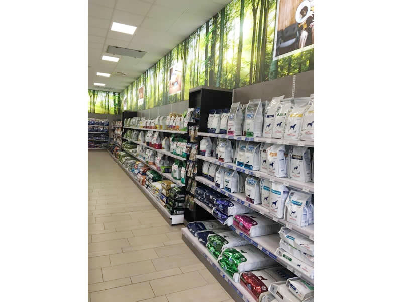Arredi per negozi di PET FOOD con scaffalature in metallo e schienali legno in colore cemento e Visual settoriali nella parte in alto Arredi per negozi di PET FOOD con scaffalature in metallo e schienali legno in colore cemento e Visual settoriali nella parte in alto