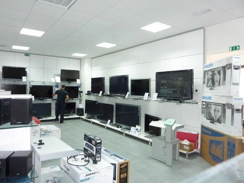 Parete espositiva con pedana al piano base e ripiani in vetro per esposizione di TV Parete espositiva con pedana al piano base e ripiani in vetro per esposizione di TV